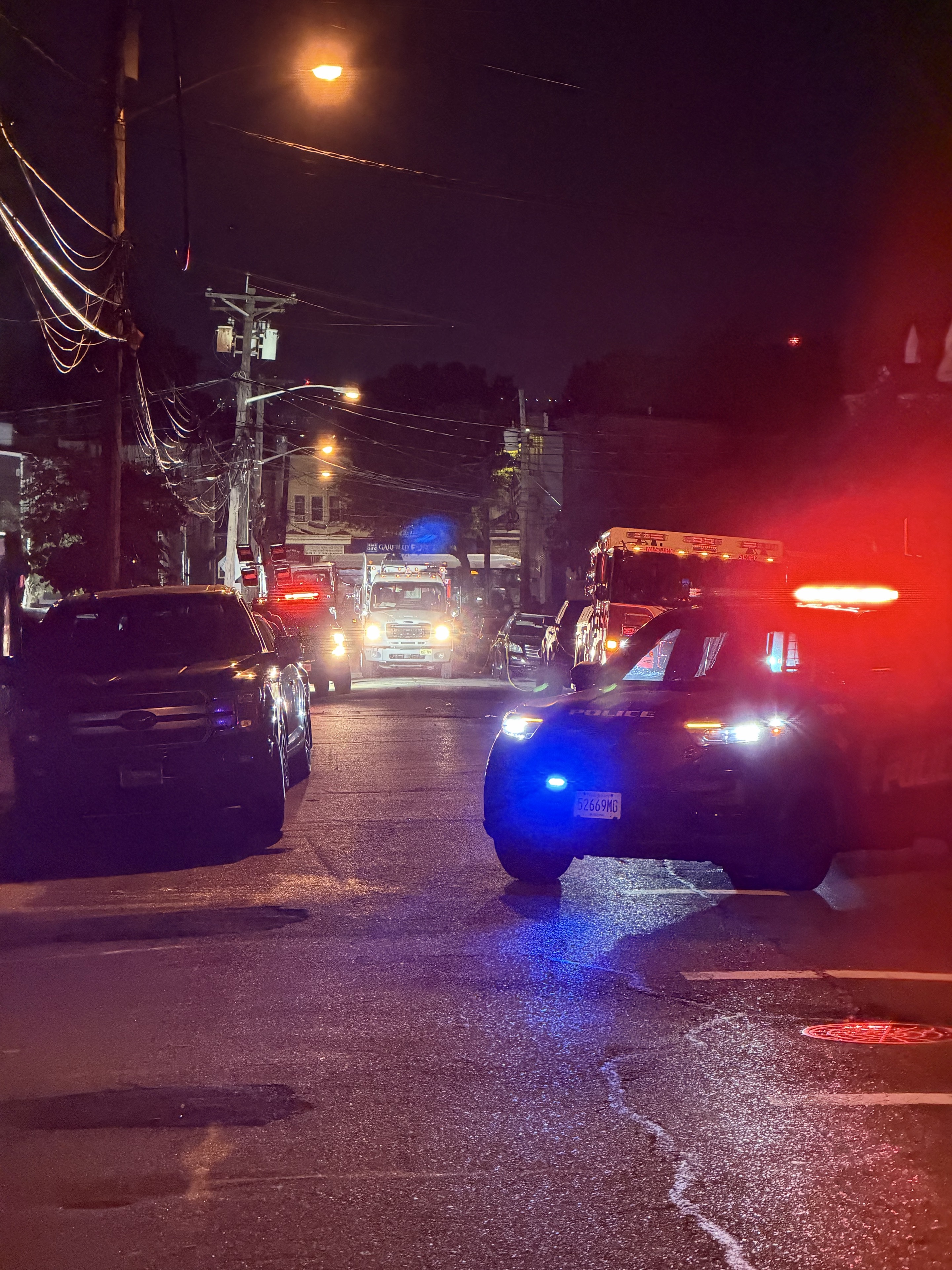 A police SUV with red and blue lights and emergency vehicles on Boyd Avenue after dark following the October 1 fire. Photo: Jersey Alerts.